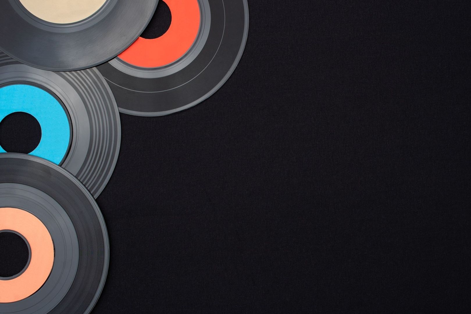 Overlapping vinyl records with colorful labels on a dark background